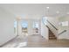 Bright living room offers light wood floors, abundant natural light, and staircase at 1257 Rhett Dr, Erie, CO 80026
