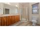 Bathroom featuring a double vanity, shower, and toilet, with modern fixtures and finishes at 13640 E Iliff Pl, Aurora, CO 80014