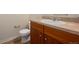 Bathroom with sink, toilet and wood-grain cabinet at 13640 E Iliff Pl, Aurora, CO 80014