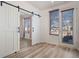 Bedroom with light wood floors, barn door to closet, and door to outdoor deck at 13640 E Iliff Pl, Aurora, CO 80014