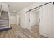 Bright entryway with light wood floors and a staircase, plus a barn door entrance at 13640 E Iliff Pl, Aurora, CO 80014