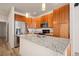 Kitchen featuring granite countertops, stainless steel appliances, and wood cabinetry at 13640 E Iliff Pl, Aurora, CO 80014