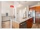 Kitchen with island featuring granite countertops, stainless steel dishwasher, wood cabinets, and stainless refrigerator at 13640 E Iliff Pl, Aurora, CO 80014