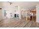 Open-concept living room with a fireplace, wood-look floors, and access to the kitchen at 13640 E Iliff Pl, Aurora, CO 80014