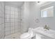 Bright white bathroom with standing shower, toilet, and sink at 11674 Claude Ct, Northglenn, CO 80233