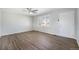 Bright living room featuring wood-look flooring, neutral walls, ceiling fan, and a large window at 11674 Claude Ct, Northglenn, CO 80233