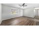 Bright living room featuring wood-look flooring, neutral walls, ceiling fan, and a large window at 11674 Claude Ct, Northglenn, CO 80233