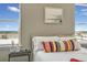 Comfortable bed with a colorful decorative pillow and an outdoor view from two windows at 1180 Crenshaw St, Castle Rock, CO 80104