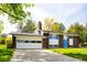 Charming brick home with a well-maintained lawn, a two-car garage, and a bright blue front door at 1757 S Van Dyke Way, Lakewood, CO 80228