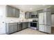 Modern kitchen with stainless steel appliances, gray cabinets, and quartz countertops at 1757 S Van Dyke Way, Lakewood, CO 80228