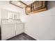 Efficient laundry room featuring a stacked washer and dryer setup and overhead cabinets for storage at 1531 S Lowell Blvd, Denver, CO 80219