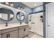 Bathroom features a dual sink vanity with black fixtures and a glass-enclosed shower at 222 Fox St, Bennett, CO 80102