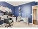 This home office boasts blue walls, white trim, a work desk, and a cute decor, making it a cozy and productive workspace at 222 Fox St, Bennett, CO 80102