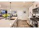 Bright kitchen boasts stainless steel appliances, granite countertops, and hardwood floors at 222 Fox St, Bennett, CO 80102