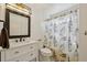 Bathroom features a vanity, mirror, toilet, and shower with a decorative floral curtain at 1001 S Nucla St, Aurora, CO 80017