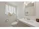 Chic half bath featuring modern vanity, decorative wallpaper, and elegant lighting at 1001 S Nucla St, Aurora, CO 80017