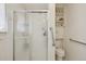 Bathroom with glass shower, built-in shelves, toilet, and grab bars for accessibility at 1001 S Nucla St, Aurora, CO 80017