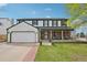 Charming two-story home with an attached garage and a brick porch, set against a vibrant blue sky at 1001 S Nucla St, Aurora, CO 80017