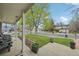 Inviting covered porch featuring comfortable seating, potted plants, and a view of a serene residential street at 1001 S Nucla St, Aurora, CO 80017
