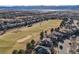 Stunning aerial view of the community with a golf course and mountain backdrop at 2816 Greensborough Dr, Highlands Ranch, CO 80129