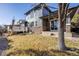 Back exterior features stone accents, deck and patio area, and a well-maintained lawn at 2816 Greensborough Dr, Highlands Ranch, CO 80129