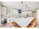 Modern kitchen features a large island with bar seating, white cabinetry, stainless appliances, and stylish lighting at 2816 Greensborough Dr, Highlands Ranch, CO 80129