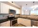 Modern kitchen featuring stainless steel appliances, tile backsplash, and white cabinetry at 1785 Morrison Ct, Superior, CO 80027
