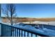 Community parking lot next to frozen pond and open field, seen from deck with railings at 1785 Morrison Ct, Superior, CO 80027