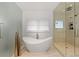 Bright bathroom showcasing soaking tub near window, separate shower, and stylish gold decor at 318 Adams St, Denver, CO 80206