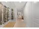 Long hallway featuring a custom glass-enclosed wine cellar on the left, with white walls and neutral carpet at 318 Adams St, Denver, CO 80206
