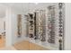 Custom glass-enclosed wine cellar with wooden floors featuring an extensive collection of wine bottles at 318 Adams St, Denver, CO 80206