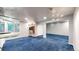 Spacious finished basement with blue carpet and room for recreation at 4826 S Ireland St, Aurora, CO 80015