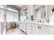 Bright bathroom with dual vanities, white cabinets, modern mirrors, and tiled floors and backsplash at 4826 S Ireland St, Aurora, CO 80015