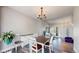 Bright dining area with hardwood floors, chandelier, and white furniture with brown table and accents at 4826 S Ireland St, Aurora, CO 80015