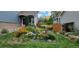 Charming home featuring a beautifully landscaped front yard with colorful flowers and lush greenery at 4826 S Ireland St, Aurora, CO 80015