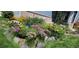 Close-up of the front yard showing meticulously arranged garden with vibrant flowers and stone accents at 4826 S Ireland St, Aurora, CO 80015