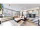 Spacious living room features an oversized sofa and ottoman with a view of the modern kitchen and dining area at 4826 S Ireland St, Aurora, CO 80015