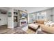 Cozy living room with a fireplace, built-in shelves, and large windows that fill the space with natural light at 4826 S Ireland St, Aurora, CO 80015