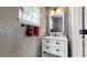 Stylish powder room with textured walls, glass block window, and modern fixtures and towel rack at 4826 S Ireland St, Aurora, CO 80015