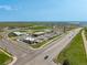 Aerial view of a commercial retail development, showing road access and parking, with a lake in the distance at 9350 Dunraven St, Arvada, CO 80007