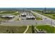 Aerial view of commercial retail development with parking, landscaping, and road access near open land, and lake at 9350 Dunraven St, Arvada, CO 80007