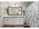 Bright bathroom featuring double vanity and shower-tub with curtain at 9350 Dunraven St, Arvada, CO 80007