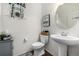 Cozy half-bath with modern fixtures, wood-look floors, pedestal sink, and charming decor at 9350 Dunraven St, Arvada, CO 80007