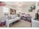 Bright bedroom featuring a chandelier, and a play area with shelves filled with colorful toys at 9350 Dunraven St, Arvada, CO 80007