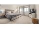 Bright bedroom featuring a large bed, neutral walls, and two big windows at 9350 Dunraven St, Arvada, CO 80007