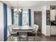 Bright dining room with white wood table and six chairs under chandelier at 9350 Dunraven St, Arvada, CO 80007