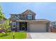 Beautiful two-story home featuring stone accents, a two car garage, and a well-maintained lawn at 9350 Dunraven St, Arvada, CO 80007