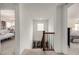 Bright hallway featuring neutral walls, carpet, and classic wood railing at 9350 Dunraven St, Arvada, CO 80007