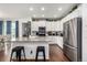 Bright kitchen features white cabinets, granite counters, stainless steel appliances, and a breakfast bar at 9350 Dunraven St, Arvada, CO 80007