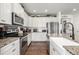 Well-equipped kitchen with granite countertops, stainless appliances, and white cabinets at 9350 Dunraven St, Arvada, CO 80007